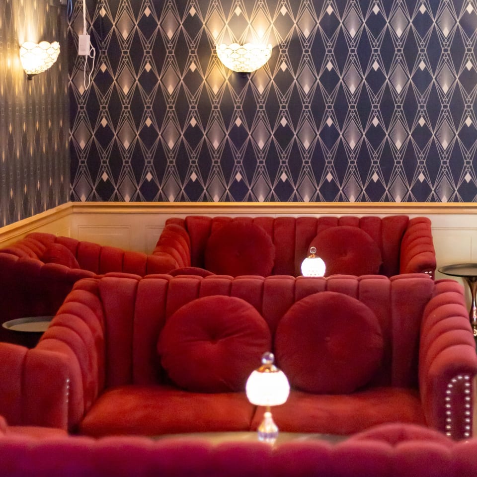 Red velvet couches and Art Deco wallpaper at Stein Haus