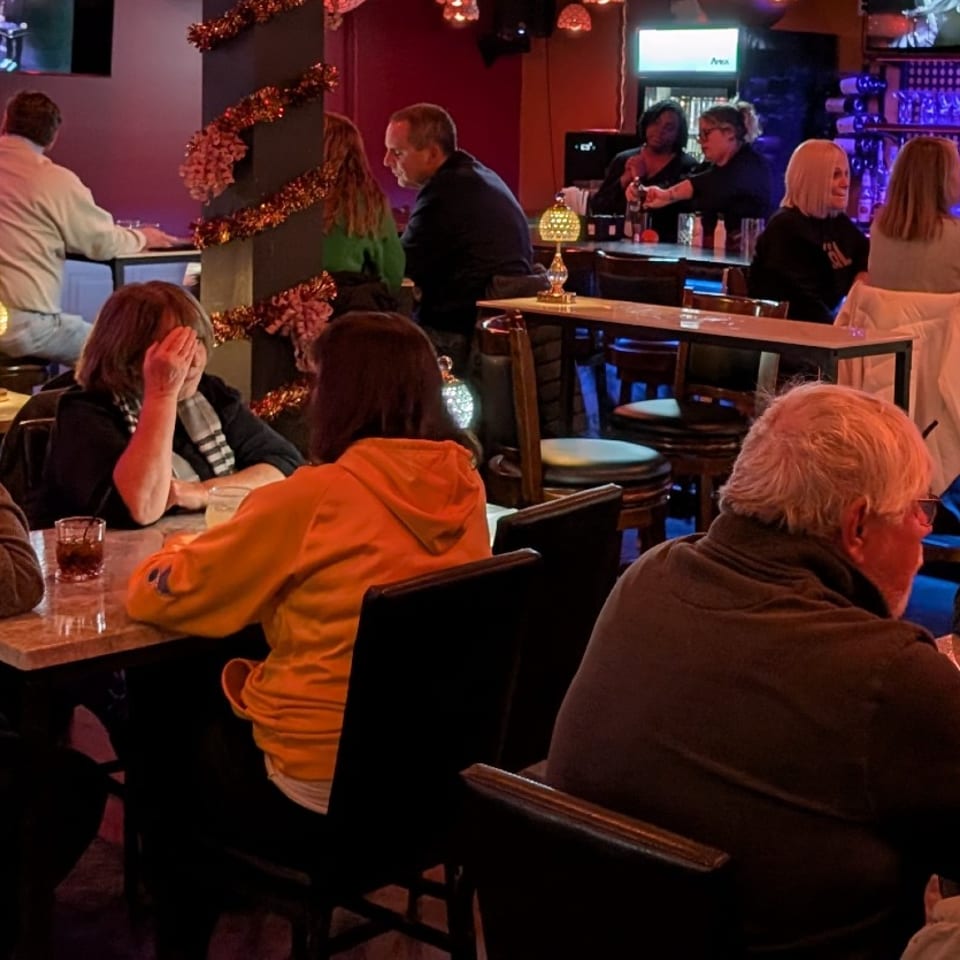 Guests gathered around tables and the Stein Haus bar